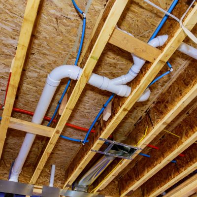 Home construction with hot red and cold blue pex pipe layout in pipes and exposed beams